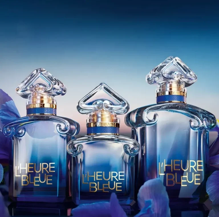 Three Guerlain L’Heure Bleue 2026 perfume bottles against a blue floral background