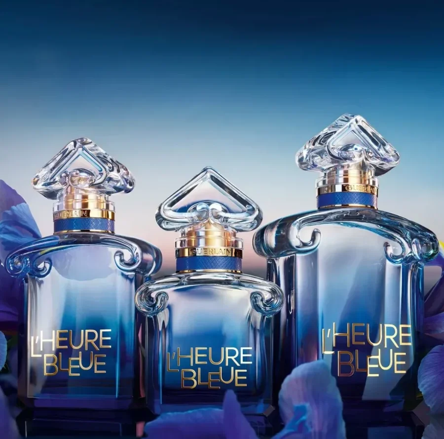Three Guerlain L’Heure Bleue 2026 perfume bottles against a blue floral background