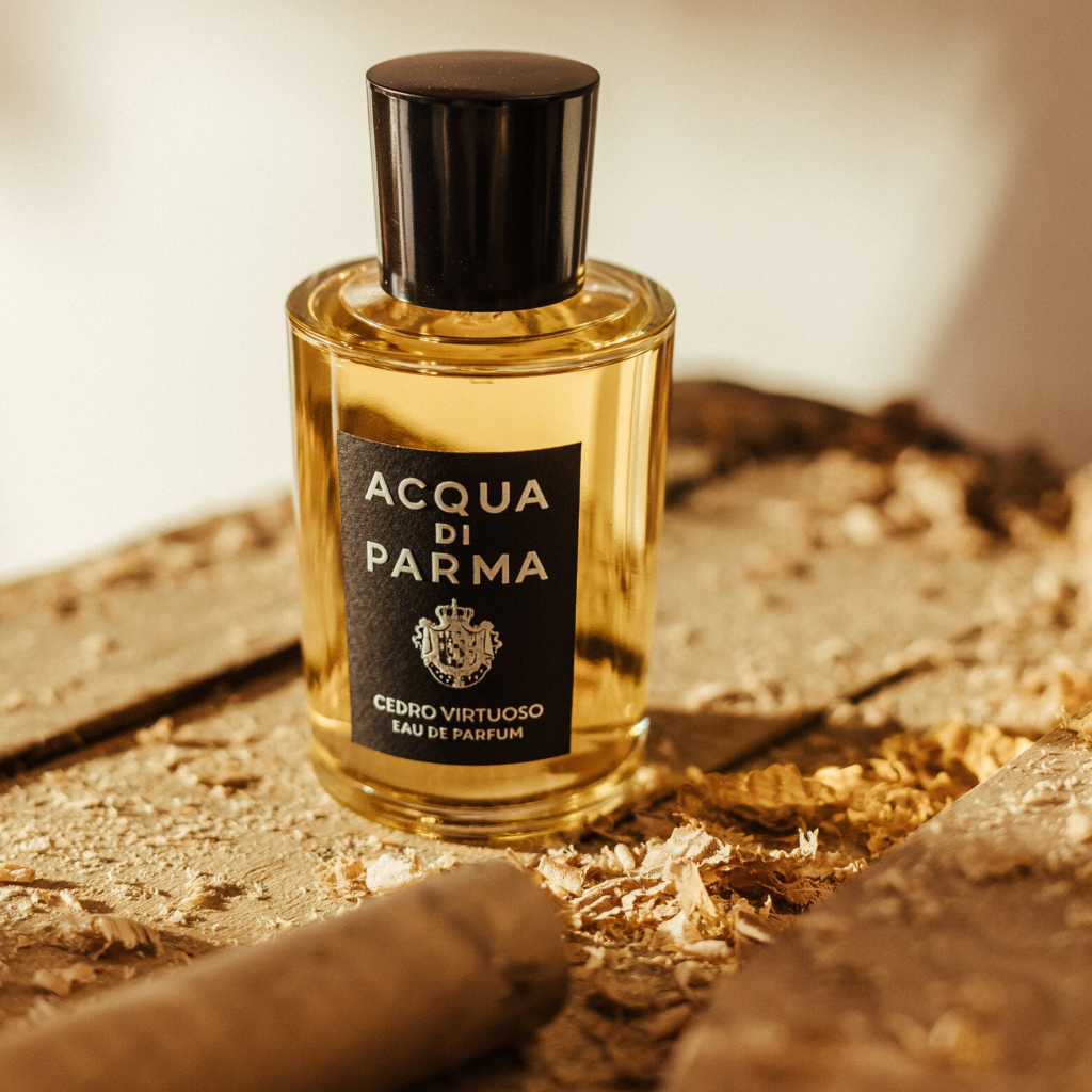 Acqua di Parma Cedro Virtuoso bottle photographed among wood shavings in a warm workshop setting