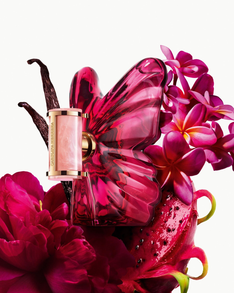 Carolina Herrera La Bomba Eau de Parfum butterfly bottle among peonies, vanilla pods and dragon fruit