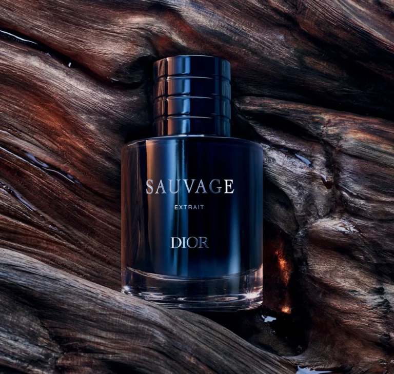 Dior Sauvage Extrait bottle resting on dark textured oud wood