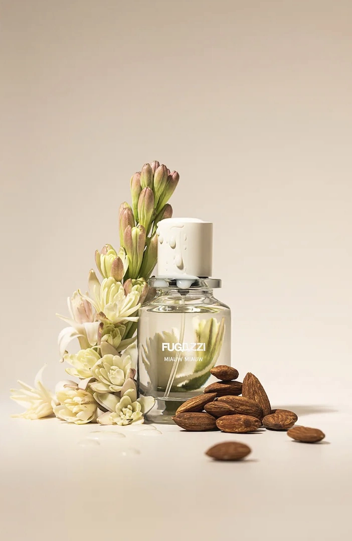 Fugazzi Miauw Miauw Eau de Parfum campaign image with roasted almonds and white flowers.