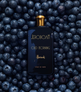 Jeroboam Oud Morning bottle resting on fresh blueberries, referencing the fragrance's top note.