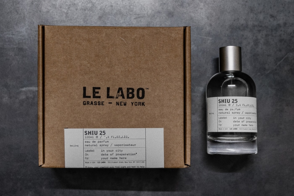 Le Labo Shiu 25 bottle beside its kraft presentation box.