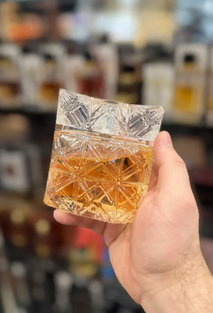 Lumière d’Issey Eau de Parfum bottle held in hand inside a perfume store