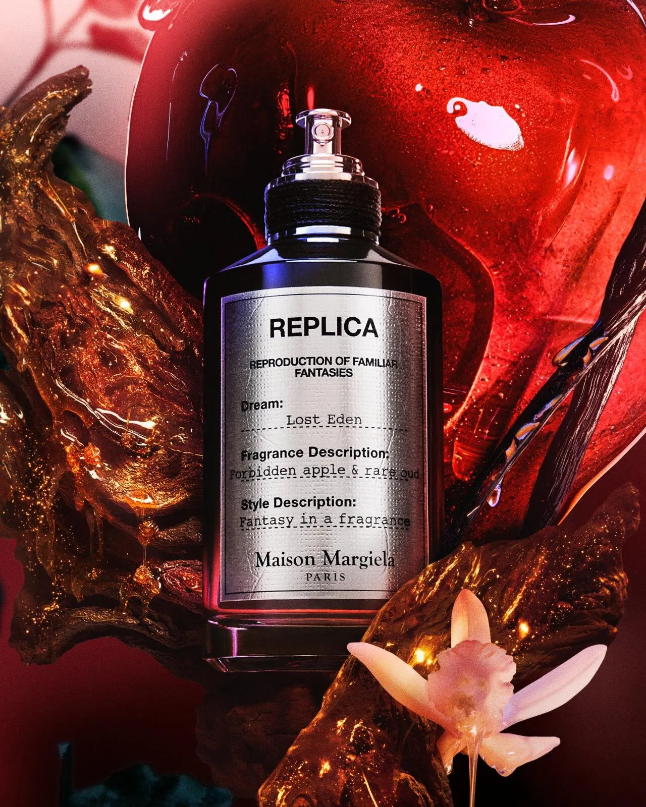 aison Margiela Replica Lost Eden perfume bottle surrounded by red apple and dark resinous textures