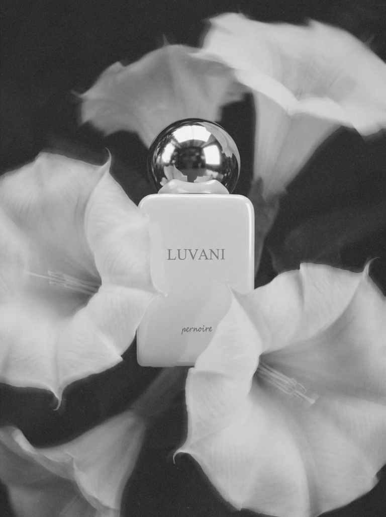 Pernoire Luvani Extrait de Parfum surrounded by moonflower-inspired white blossoms