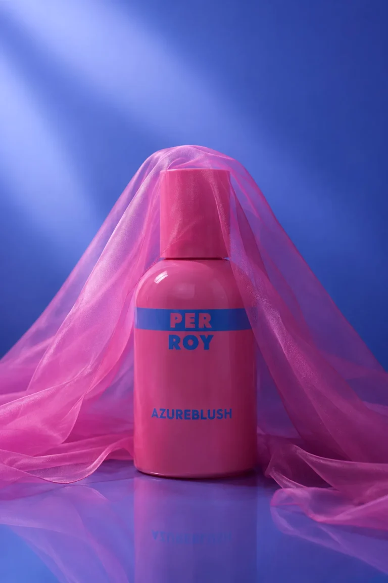 Pink Perroy Azureblush perfume bottle surrounded by flowing fabric