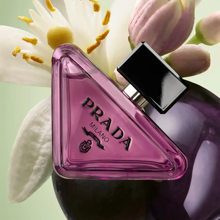 Prada Paradoxe Sweet Chemistry perfume bottle surrounded by orange blossom and blackcurrant imagery