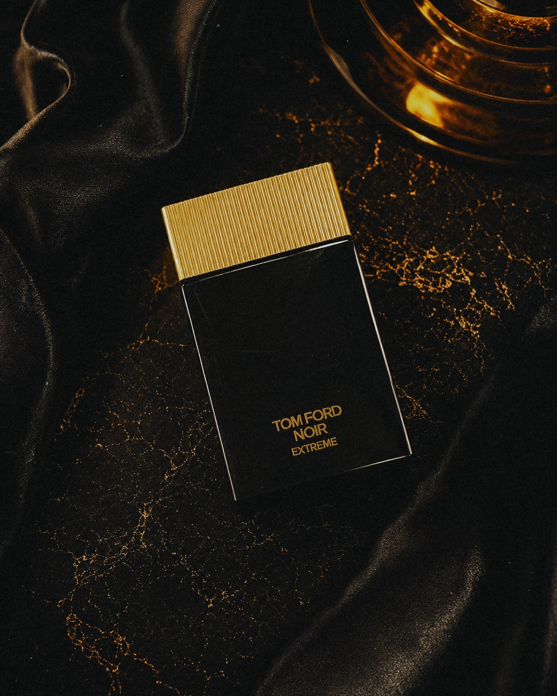 Tom Ford Noir Extreme review bottle on black fabric with gold details