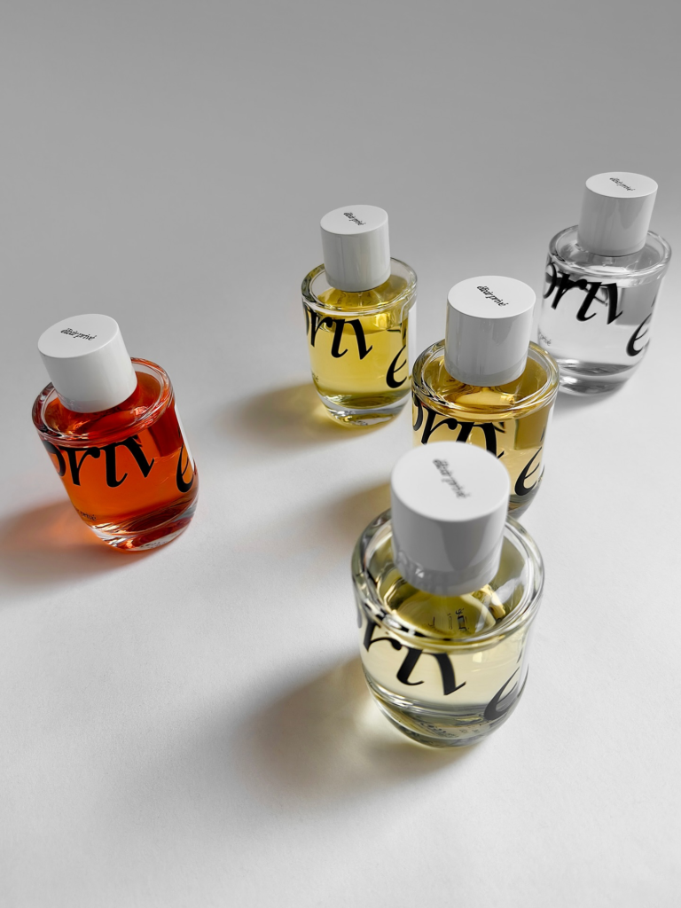 Élixir Privé perfume bottles arranged on a white background with coloured fragrances inside.