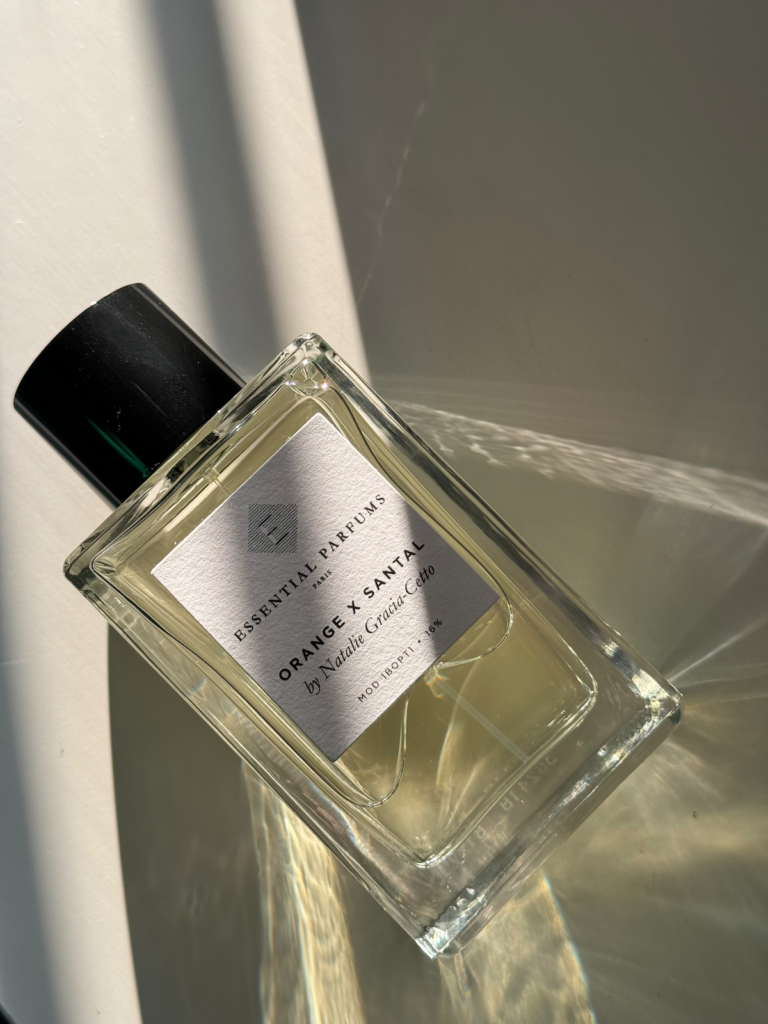Essential Parfums Orange X Santal perfume bottle in natural light