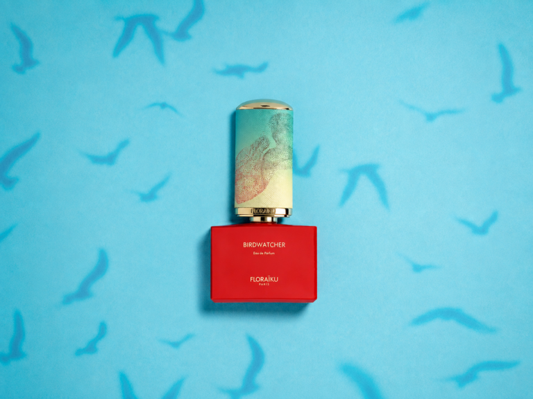 Red Floraïku Birdwatcher bottle on a blue background with shadows of birds in flight