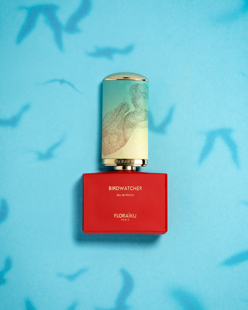 Floraïku Birdwatcher bottle on a blue background with shadows of flying birds