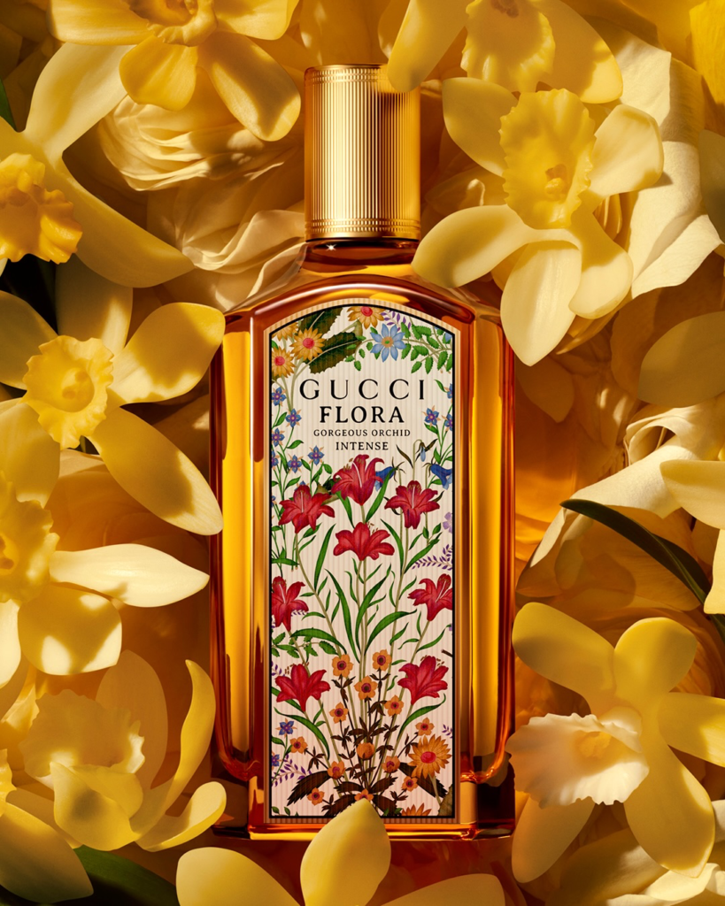 Close-up of the Gucci Flora Gorgeous Orchid Intense golden bottle among yellow flowers