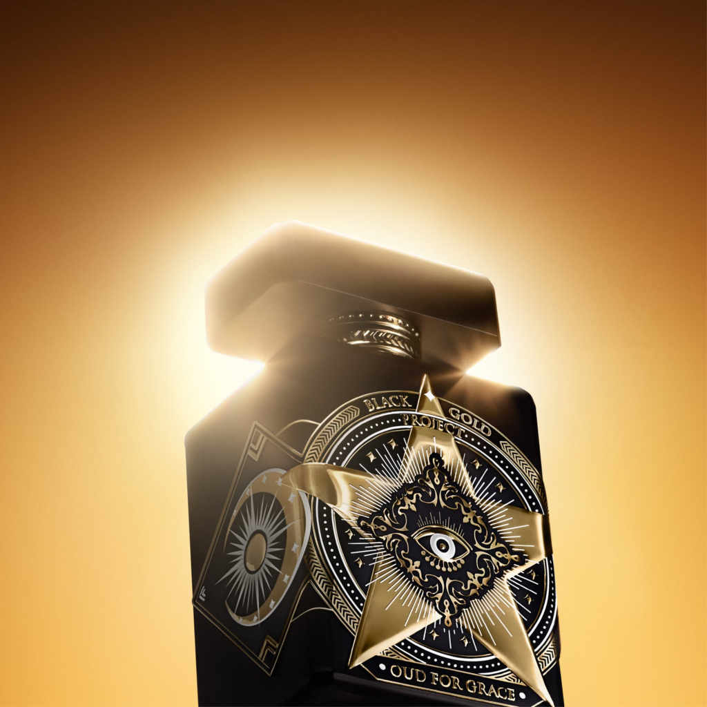Close-up of the Initio Oud for Grace bottle and golden Tree of Life emblem