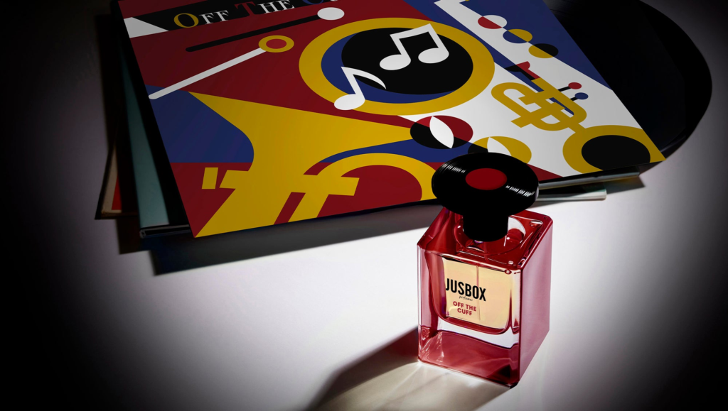 JUSBOX Off the Cuff bottle beside vinyl records and jazz-inspired artwork