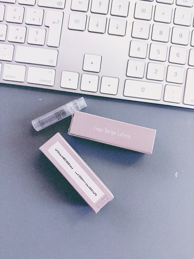 L'Eau Serge Lutens 1 ml sample vial and pale sample boxes beside a keyboard.