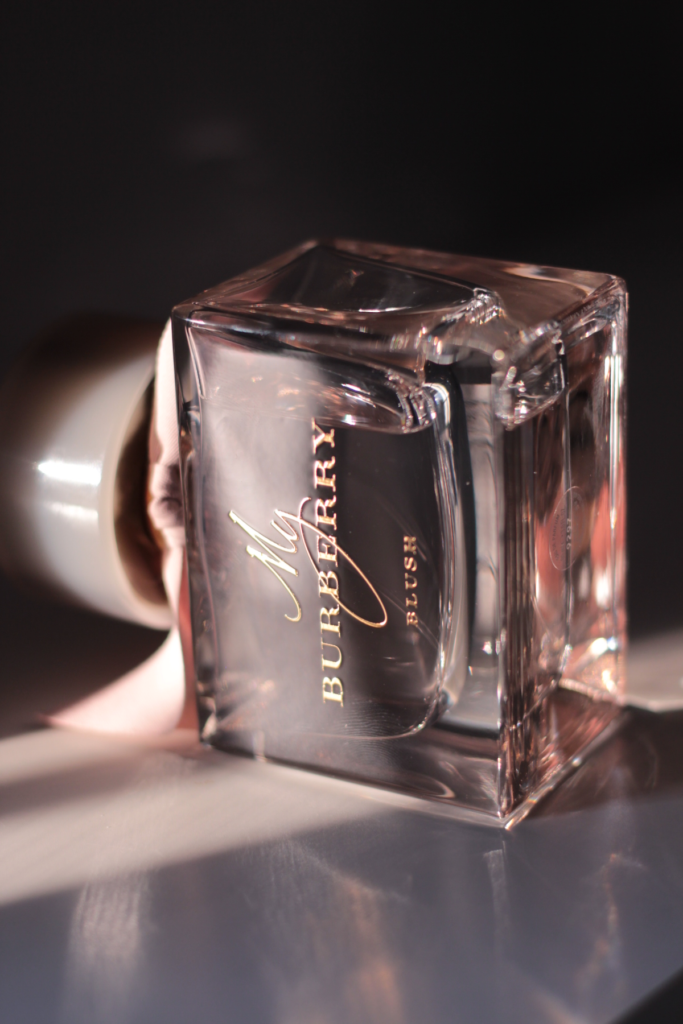 My Burberry Blush perfume bottle reflecting warm light through pink glass