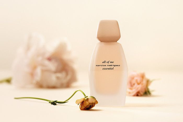 Narciso Rodriguez All of Me Essentiel bottle with blurred pink peonies in the background