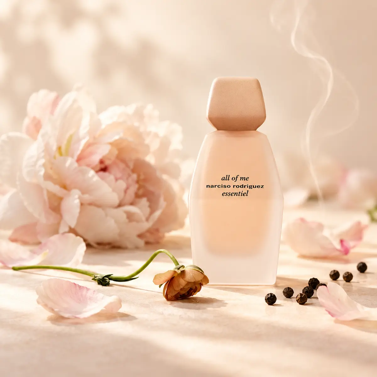 Narciso Rodriguez All of Me Essentiel bottle surrounded by a peony, dried petals and black peppercorns