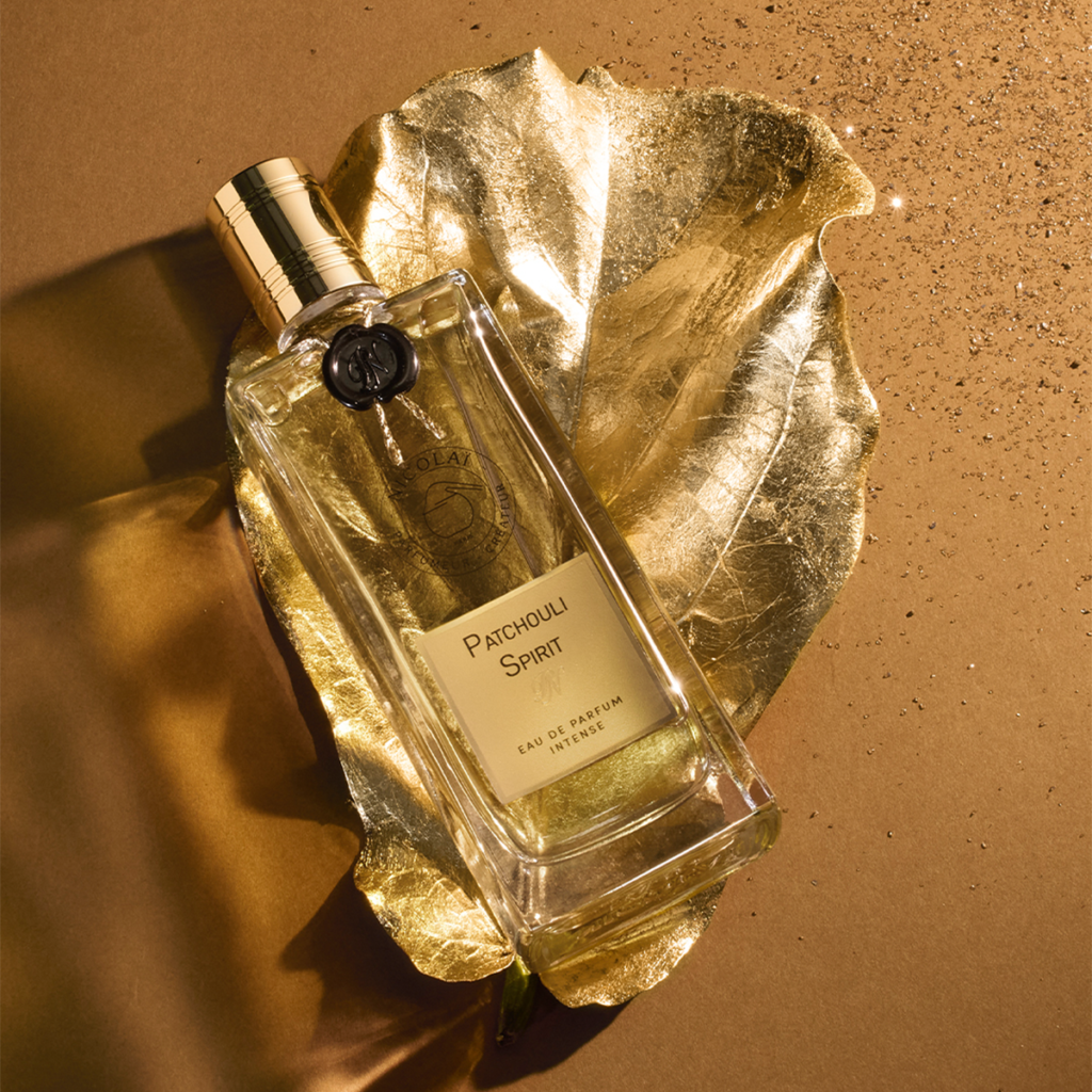 Nicolaï Patchouli Spirit Eau de Parfum Intense bottle photographed diagonally on a metallic gold leaf