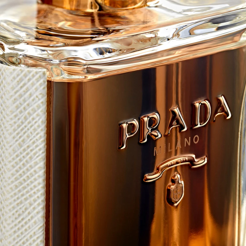 Close-up of the gold Prada Milano emblem and glass on the La Femme Prada bottle
