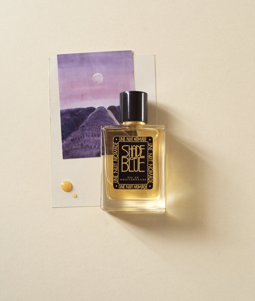 Une Nuit Nomade Shade of Blue bottle with a violet Mediterranean landscape postcard