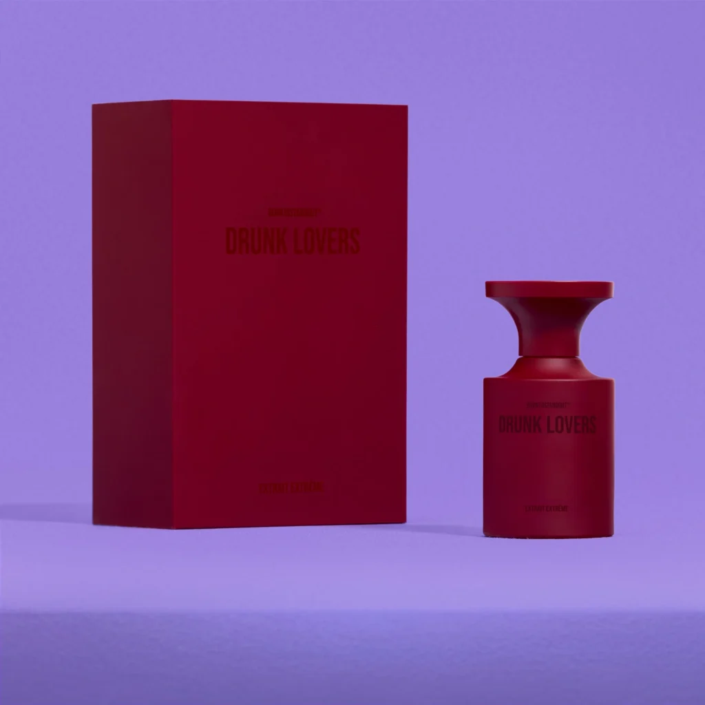 BORNTOSTANDOUT Drunk Lovers Extrait Extrême red perfume bottle and matching packaging against a purple background