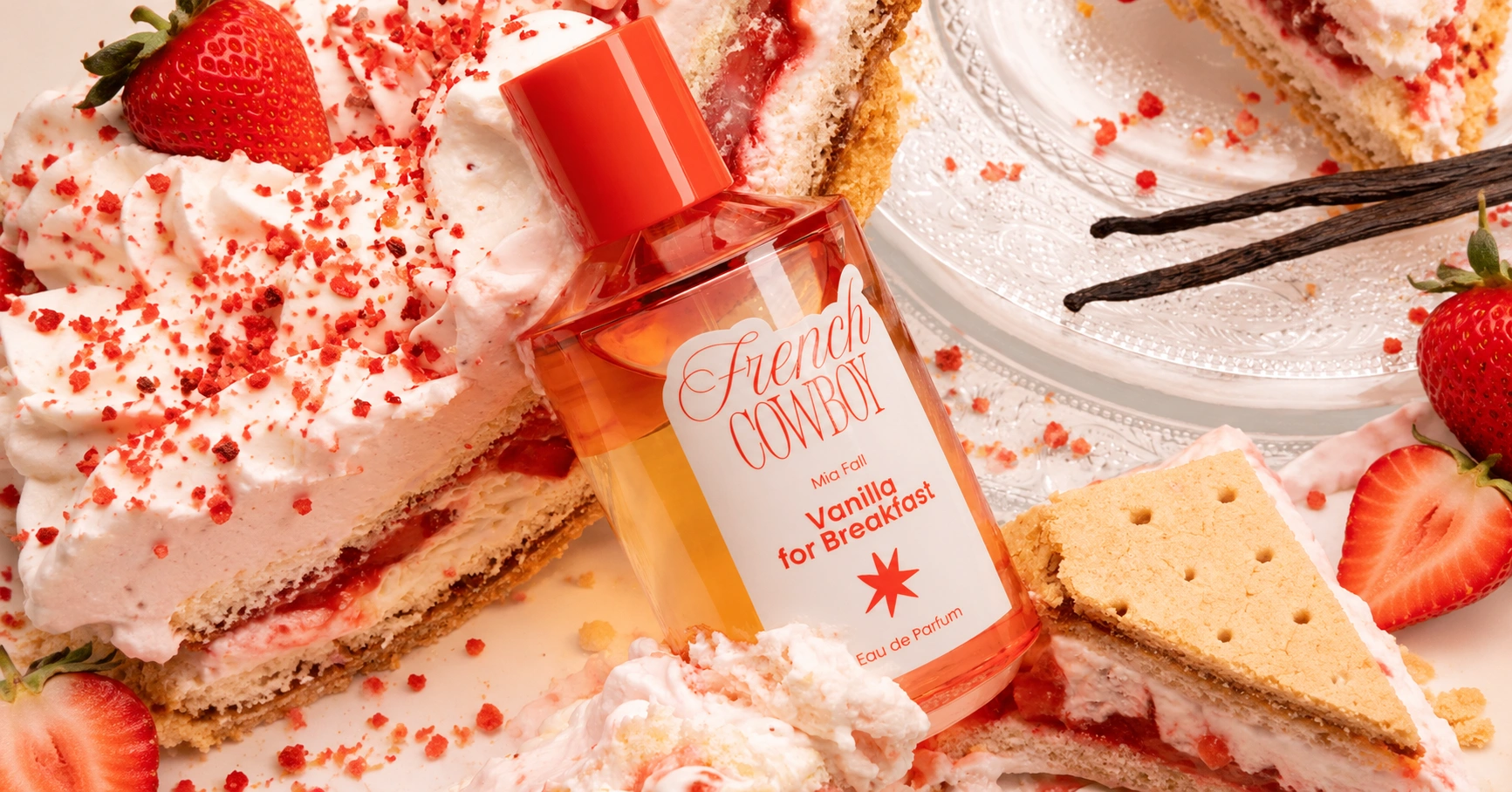 French Cowboy Vanilla for Breakfast perfume bottle surrounded by strawberry cake, whipped cream, biscuits and vanilla pods.