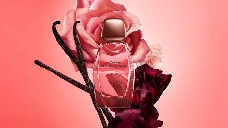 Narciso Rodriguez All of Me Intense perfume surrounded by pink roses, dark burgundy petals and vanilla pods against a pink background.