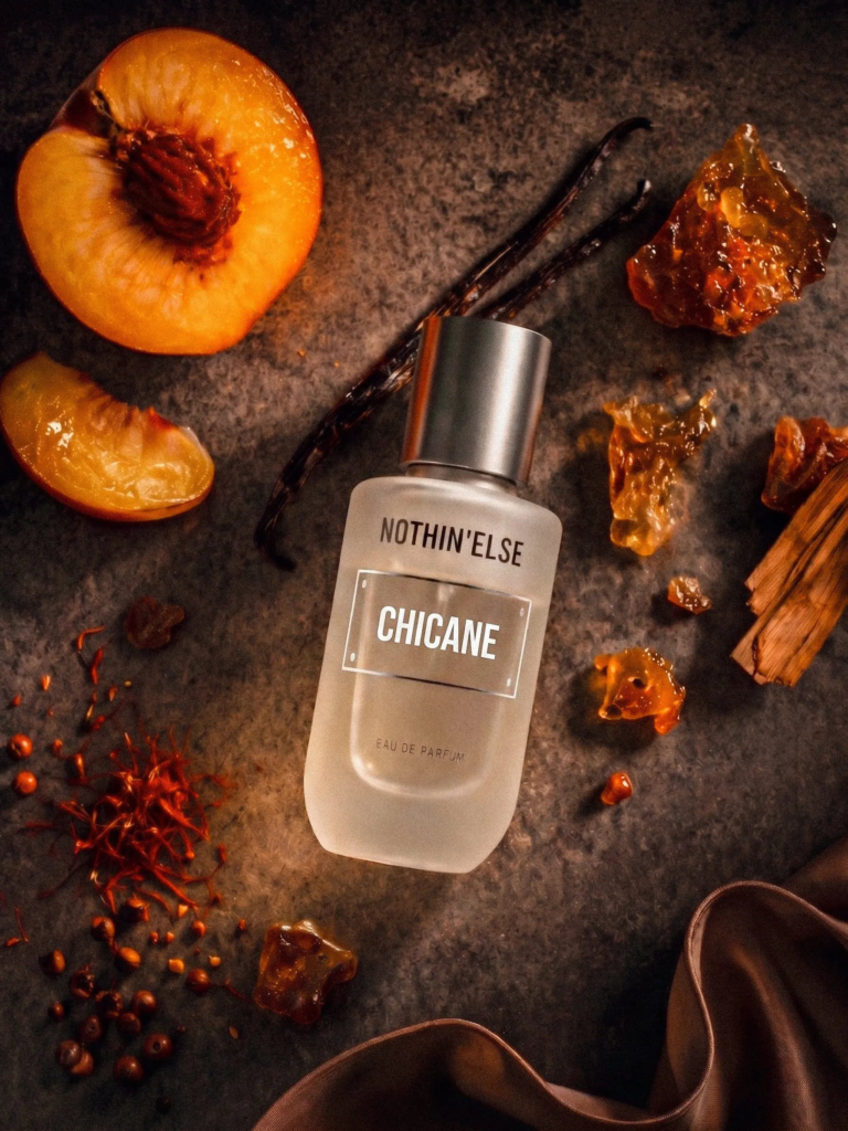 Nothin'Else Chicane Eau de Parfum surrounded by peach vanilla and aromatic materials