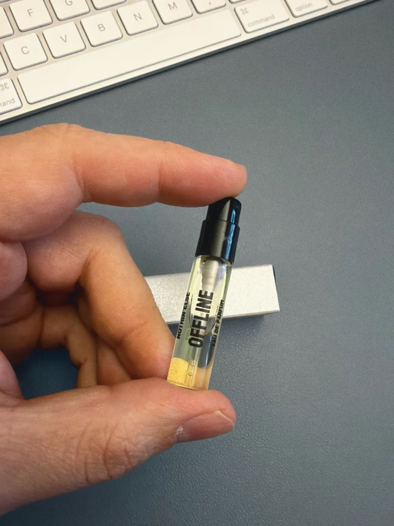 Hand holding a 2 ml NOTHIN’ELSE Offline sample beside a keyboard