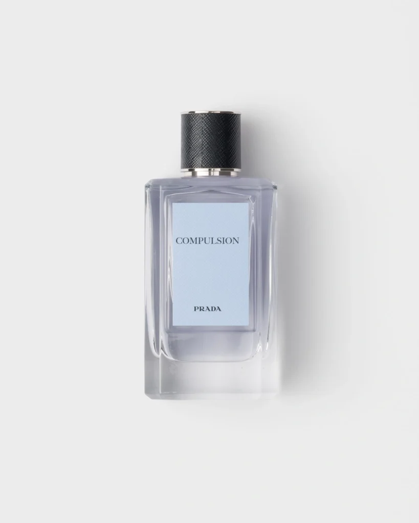 Prada Compulsion Eau de Parfum 100 ml bottle with pale blue label and textured black cap.