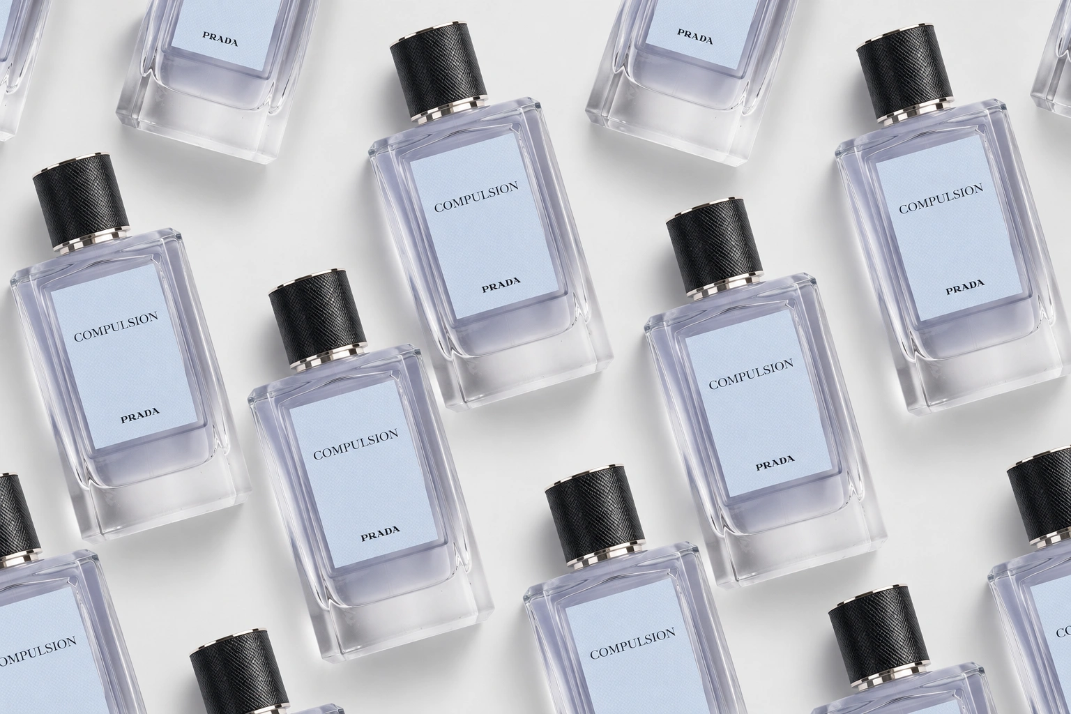 Prada Compulsion Eau de Parfum bottles arranged in a diagonal pattern for an editorial fragrance cover.
