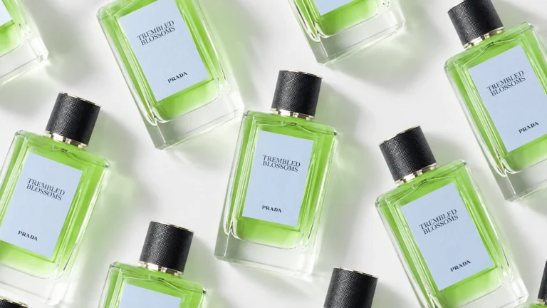 Prada Trembled Blossoms perfume bottles arranged in a diagonal pattern, featuring apple-green liquid and pale blue labels.