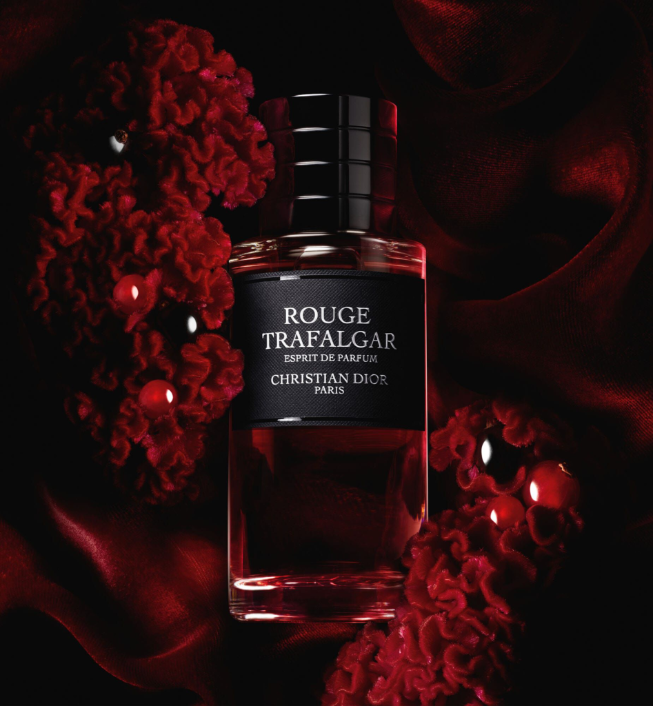 Rouge Trafalgar Esprit de Parfum bottle with deep red floral background