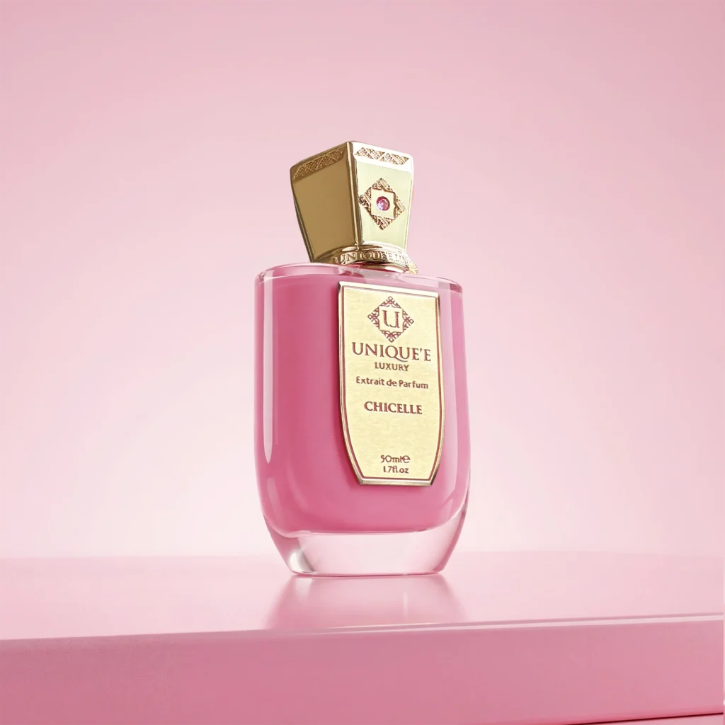 Pink Chicelle perfume bottle by Unique’e Luxury with a gold cap on a reflective pink surface.